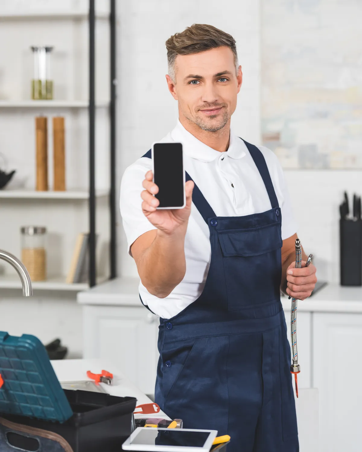 Handwerker auf der Baustelle, das Handy in der Hand